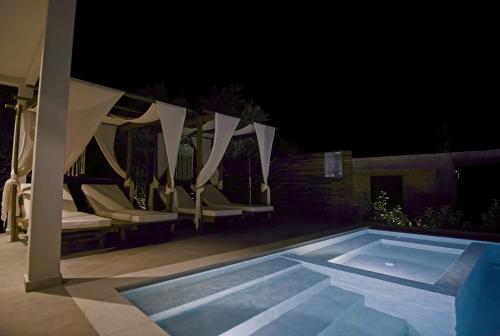 a swimming pool with chairs and a canopy at night at Villa Mourelo luxury villa in chania with private pool jacuzzi in Chania Town