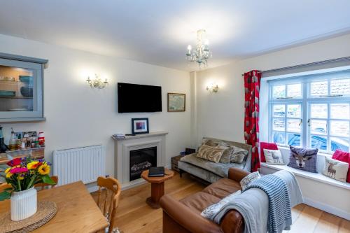a living room with a couch and a fireplace at The Snug - A Quaint Mews Cottage City Centre in Wells