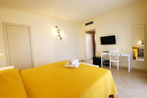 a bedroom with a yellow bed and a desk at Verdello Home Savoca in Savoca 