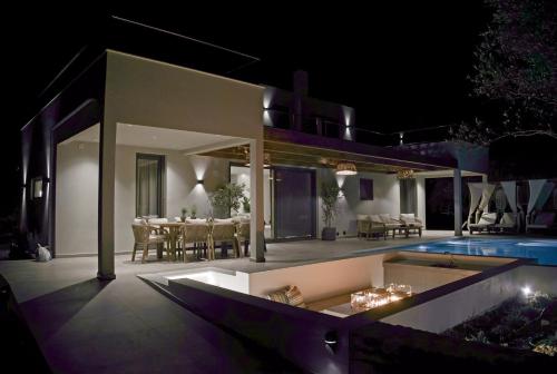 a villa with a swimming pool at night at Villa Mourelo luxury villa in chania with private pool jacuzzi in Chania Town