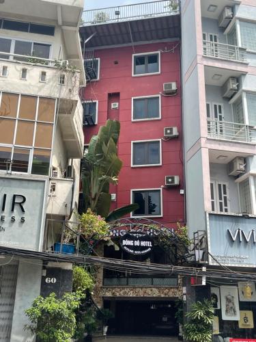 a red building in the middle of some buildings at Đông Đô Hotel in Hai Phong