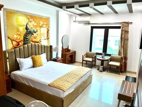 a bedroom with a bed with a painting on the wall at Đông Đô Hotel in Hai Phong