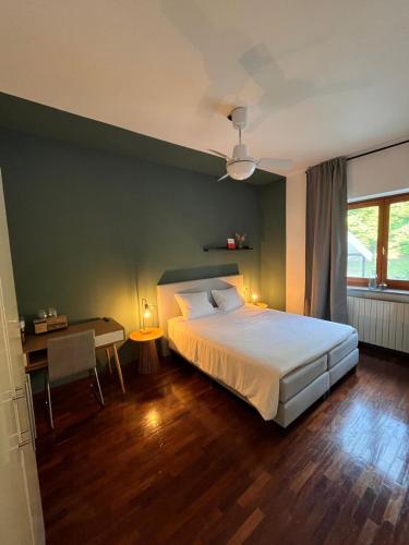 a bedroom with a bed and a table and a desk at Casa Alba Blu in Dogliani