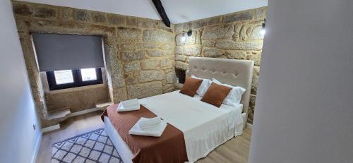 a small bedroom with a bed and a tv at Vilar Rural Houses - Casa dos Avós in Tangil