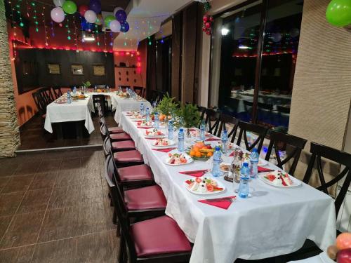 a group of tables with plates of food on them at Romantica Forest Guest House in Dospat