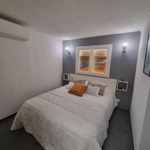 - une chambre avec un grand lit et 2 photos sur le mur dans l'établissement Joli T3 à 200M Plage Sud 4 personnes Parking Calme, au Grau-du-Roi