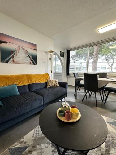 un salon avec un canapé et une table dans l'établissement Joli T3 à 200M Plage Sud 4 personnes Parking Calme, au Grau-du-Roi