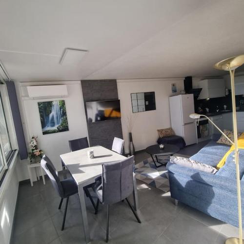 un salon avec une table et un canapé dans l'établissement Joli T3 à 200M Plage Sud 4 personnes Parking Calme, au Grau-du-Roi