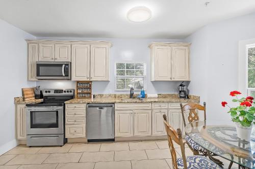a kitchen with white cabinets and a table at Villa Mulvey # 4 in St. Augustine