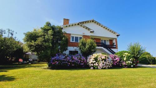 a house with a bunch of flowers in the yard at Camino a las Sopeñas in Oreña
