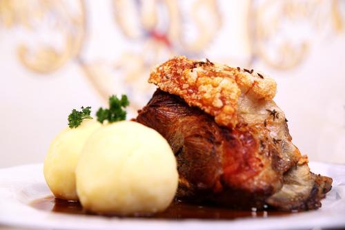 a piece of meat with potatoes on a plate at Hotel Gasthof Zur Post in Königstein in der Oberpfalz