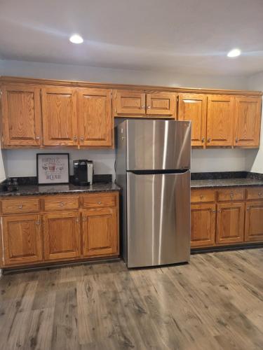 ファイエットビルにある4 bd home close to Fort Libertyのキッチン(ステンレス製の冷蔵庫、木製キャビネット付)