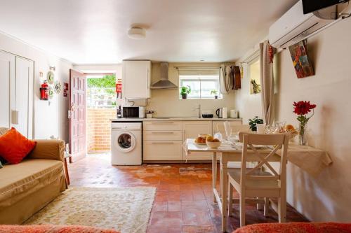 een keuken met een bank en een tafel in een kamer bij Studio & Garden in Lissabon