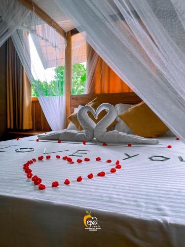 a bed with a heart made out of red roses at Habarana Tree House Ambasewana Resort in Habarana
