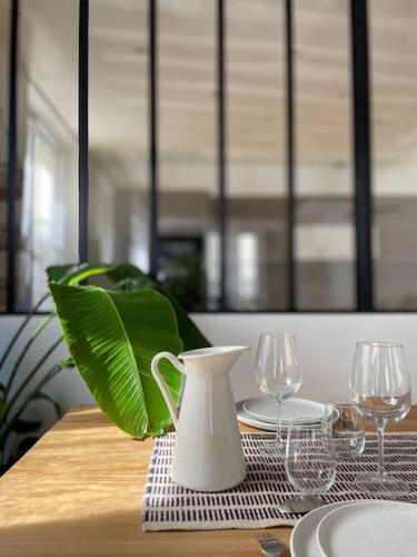une table avec un vase blanc et des lunettes dans l'établissement Appartement Place des Vosges, 1 chambres 4 P, à Paris