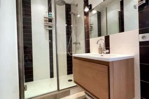 une salle de bain avec un lavabo et une douche dans l'établissement Appartement Place des Vosges, 1 chambres 4 P, à Paris