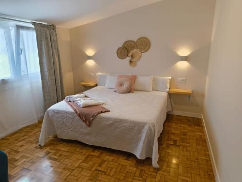 a bedroom with a large bed with towels on it at Villa Galicia (Padrón) in Padrón