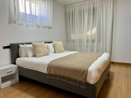 Un dormitorio con una cama grande y una ventana. en Junquera Playa, en Moaña