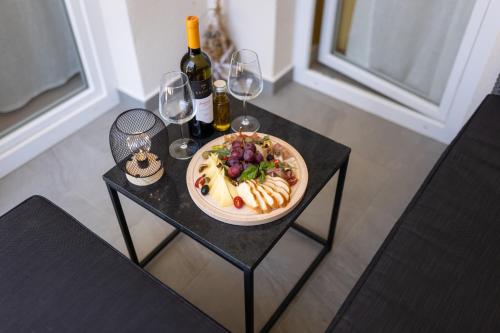 a table with a plate of food and wine glasses at Lussin in Mali Lošinj