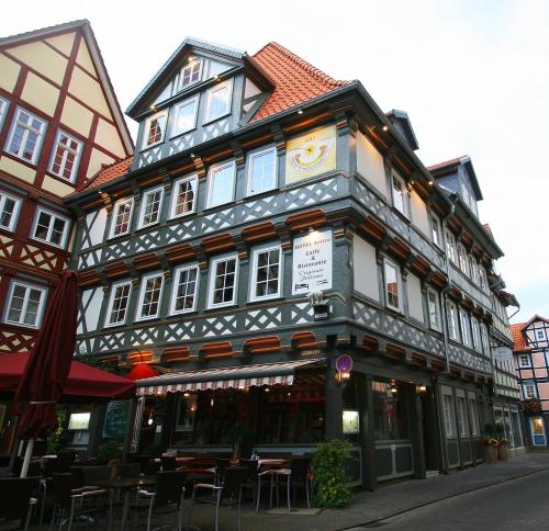 a building with tables and chairs in front of it at Fachwerk-Hotel Eisenbart in Hannoversch Münden