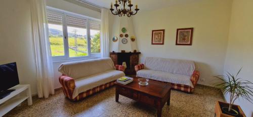 a living room with two chairs and a coffee table at Camino a las Sopeñas in Oreña