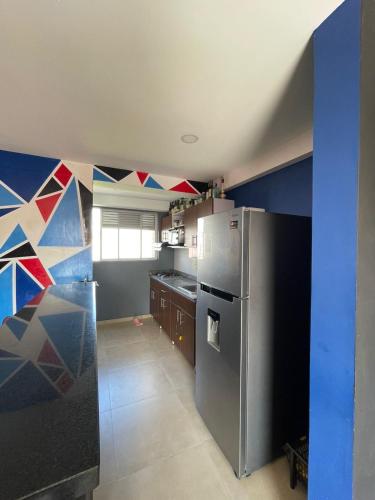 a kitchen with a stainless steel refrigerator and blue walls at Apartamento amoblado nuevo in Pereira