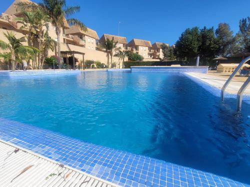 a large swimming pool with blue water at Alcaidesa, luxury apartment with sea views in Alcaidesa