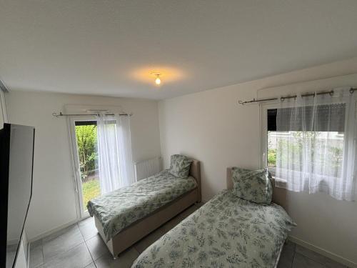 Un dormitorio con dos camas y una ventana. en Appartement Biscarrosse, en Biscarrosse