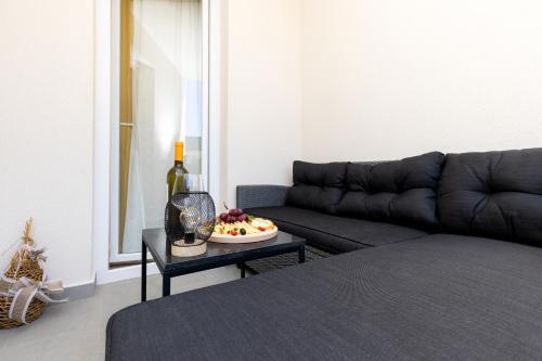 a living room with a couch and a table with a plate of fruit at Lussin in Mali Lošinj