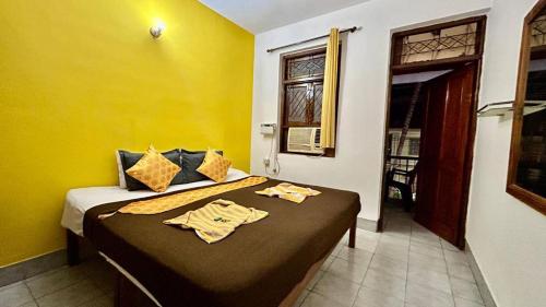 a bedroom with a bed with two robes on it at Muffys Apartment in Old Goa