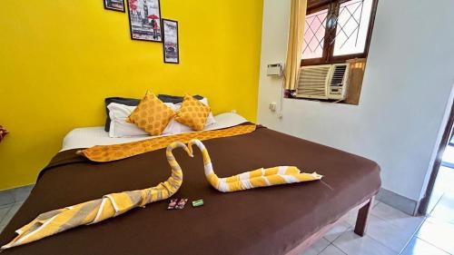 a bedroom with a bed with two blankets on it at Muffys Apartment in Old Goa