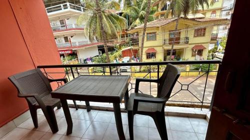 a table and chairs on a balcony with a view of a building at Muffys Apartment in Old Goa