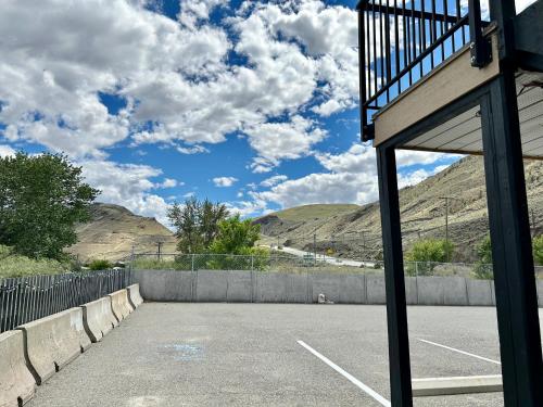 an empty parking lot with mountains in the background at Riverside Motel Cache Creek in Cache Creek