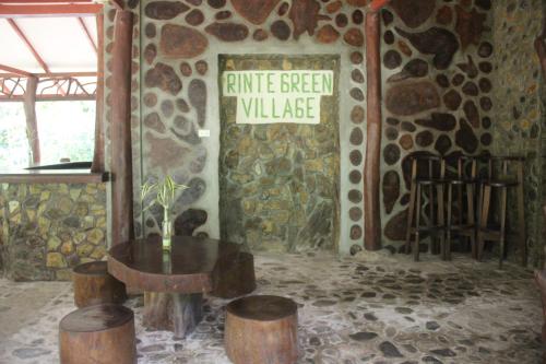 a room with a table and a sign on a wall at Rinte Green Village & Bukit Lawang Jungle Trekking in Bukit Lawang