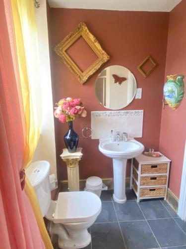 a bathroom with a sink and a toilet and a mirror at Upton Country Park Guest House in Northampton