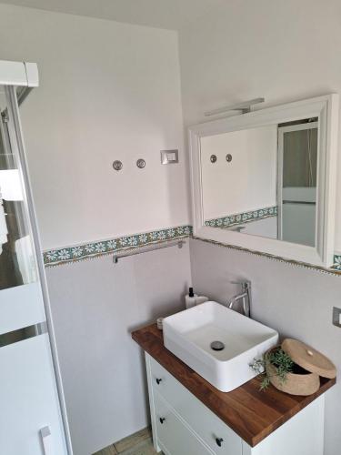 a bathroom with a white sink and a mirror at Casa vacanze green house in Terrasini