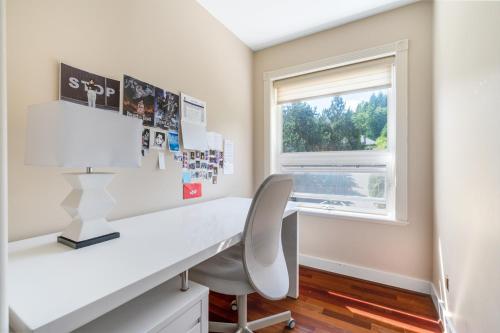 a white desk with a chair and a window at The West Vancouver luxurious house in West Vancouver