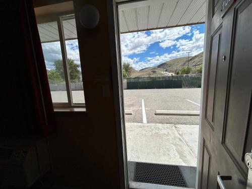 an open door with a view of a parking lot at Riverside Motel Cache Creek in Cache Creek