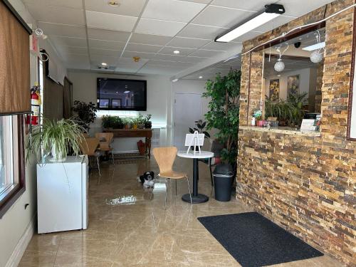 a room with a brick wall and a table with a dog at Riverside Motel Cache Creek in Cache Creek