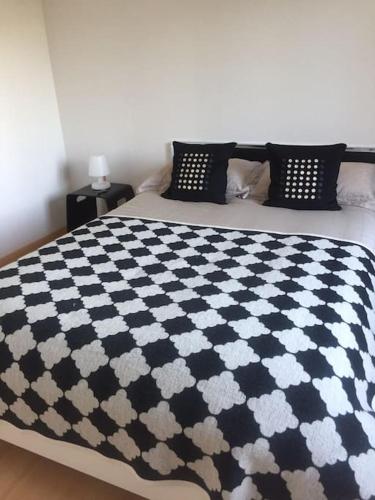 - un lit avec une couette en noir et blanc dans l'établissement Appartement T2 Les papillons, à Arcachon