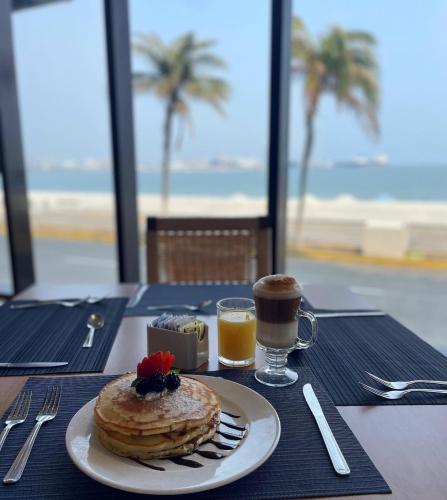 a table with a plate of pancakes and a cup of coffee at DoubleTree by Hilton Veracruz in Veracruz
