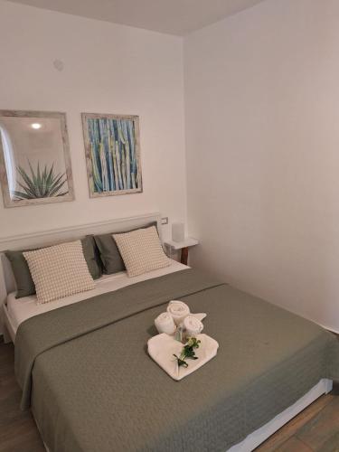 a bedroom with a bed with towels and flowers on it at Casa vacanze green house in Terrasini