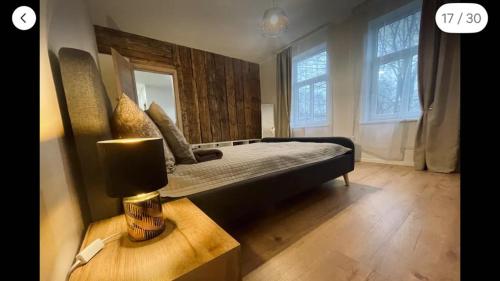 Un dormitorio con una cama y una lámpara sobre una mesa. en Tikrai nelis, en Liepāja