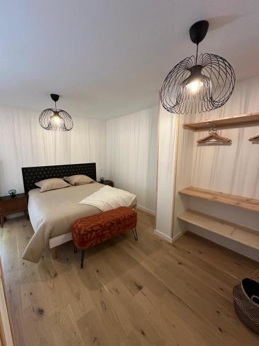 - une chambre avec un lit et deux lustres dans l'établissement Les Marais Blancs à Picauville, à Picauville