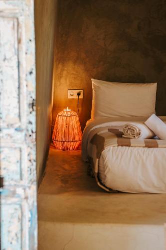 a bedroom with a bed with a lamp next to it at Hotel & Spa La Ferme El Dar in Marrakech