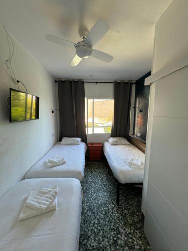 a room with two beds and a ceiling fan at Pension RIOKA CALPE in Calpe