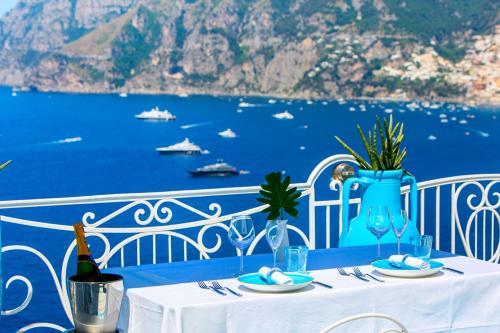 a table with a bottle of wine sitting on a balcony at Hotel Smeraldo in Praiano