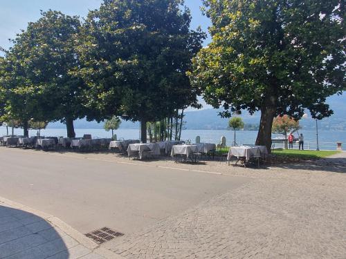 a row of tables and trees on the side of a road at Appartamenti vicino al lago con bikeparking in Verbania