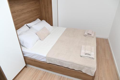 Un dormitorio con una cama con sábanas y almohadas blancas. en Villa Krivokapic, en Trebinje