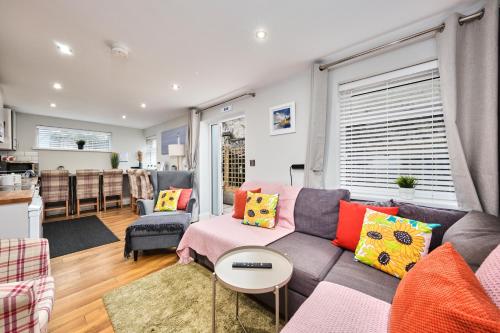 ein Wohnzimmer mit einem grauen Sofa und bunten Kissen in der Unterkunft Princess Green 4 - Portrush by the Sea in Portrush